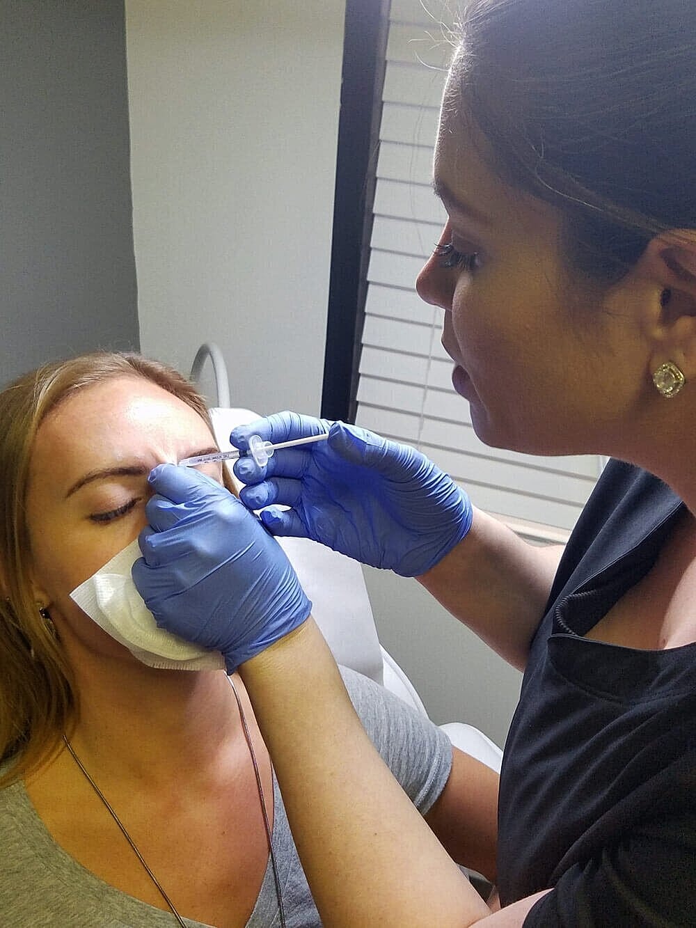 Woman receiving cosmetic treatment from professional.