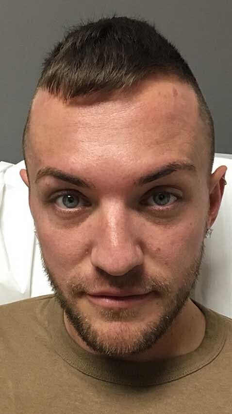 Person with a close-cropped haircut and beard.