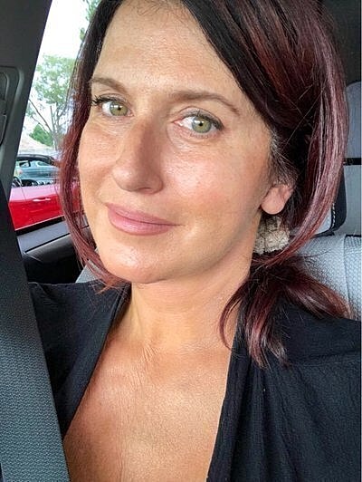 Woman smiling in car, natural lighting.