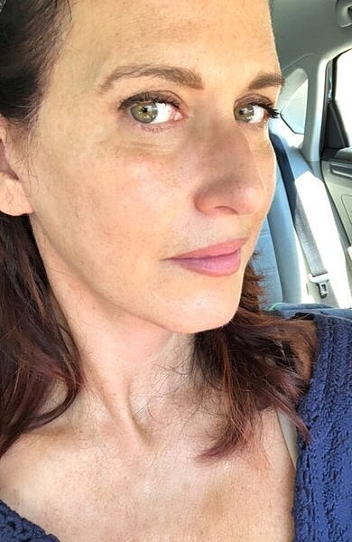 Woman smiling in a car setting.