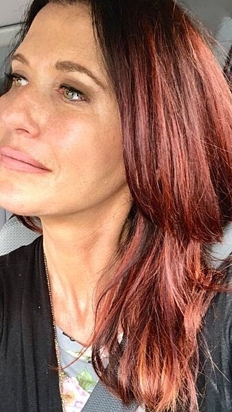 Woman with long, wavy reddish-brown hair.