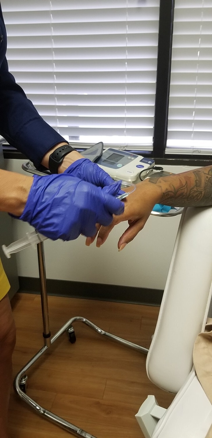 Healthcare professional administering treatment to patient.
