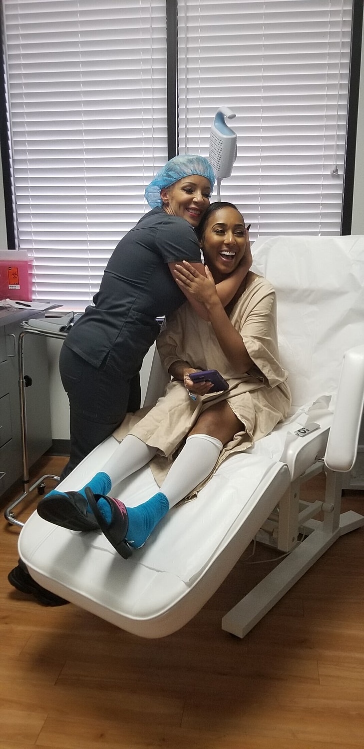 Patient and nurse smiling together in clinic.