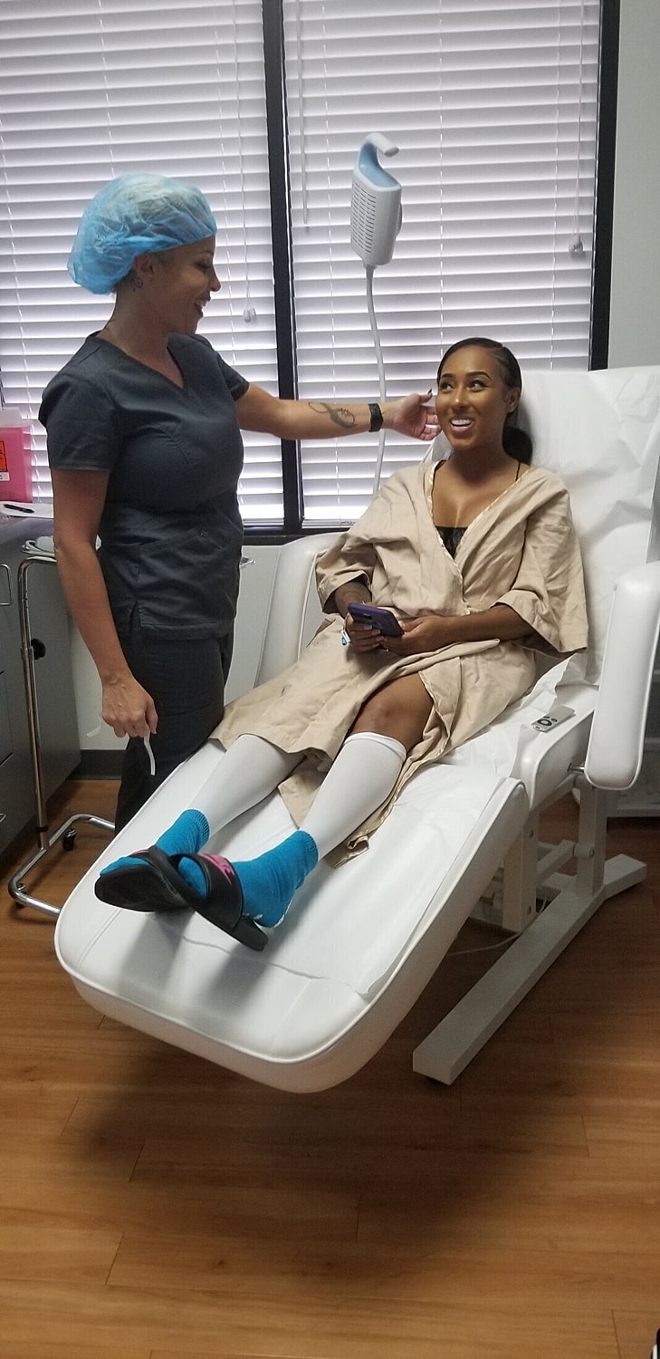 Patient seated in treatment chair, smiling with nurse.