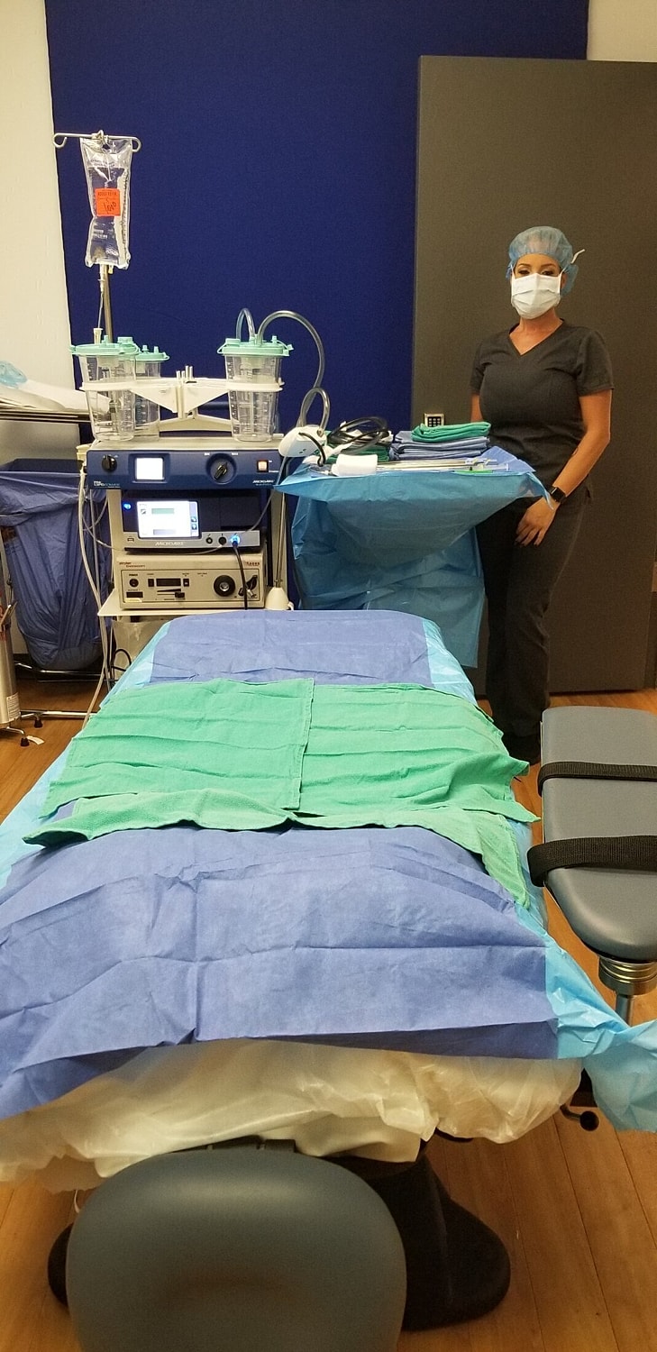 Surgical room setup with medical equipment and staff.