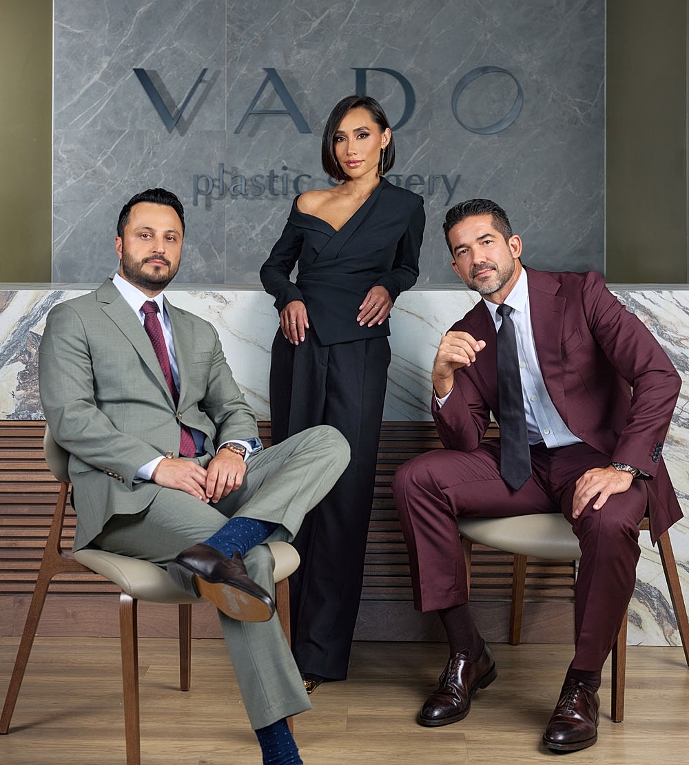 Three professionals posed in plastic surgery clinic.