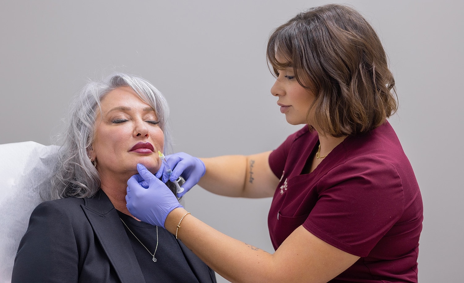 Cosmetic treatment session between practitioner and client.