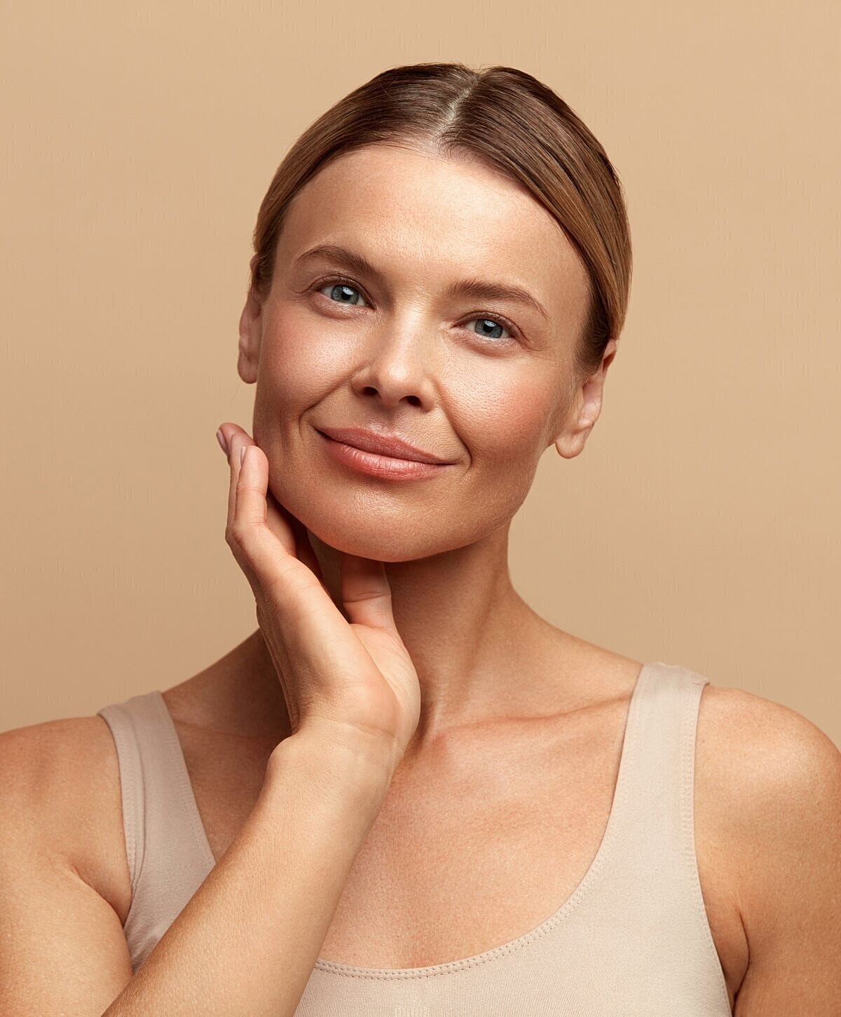 Woman smiling with natural makeup and soft lighting.