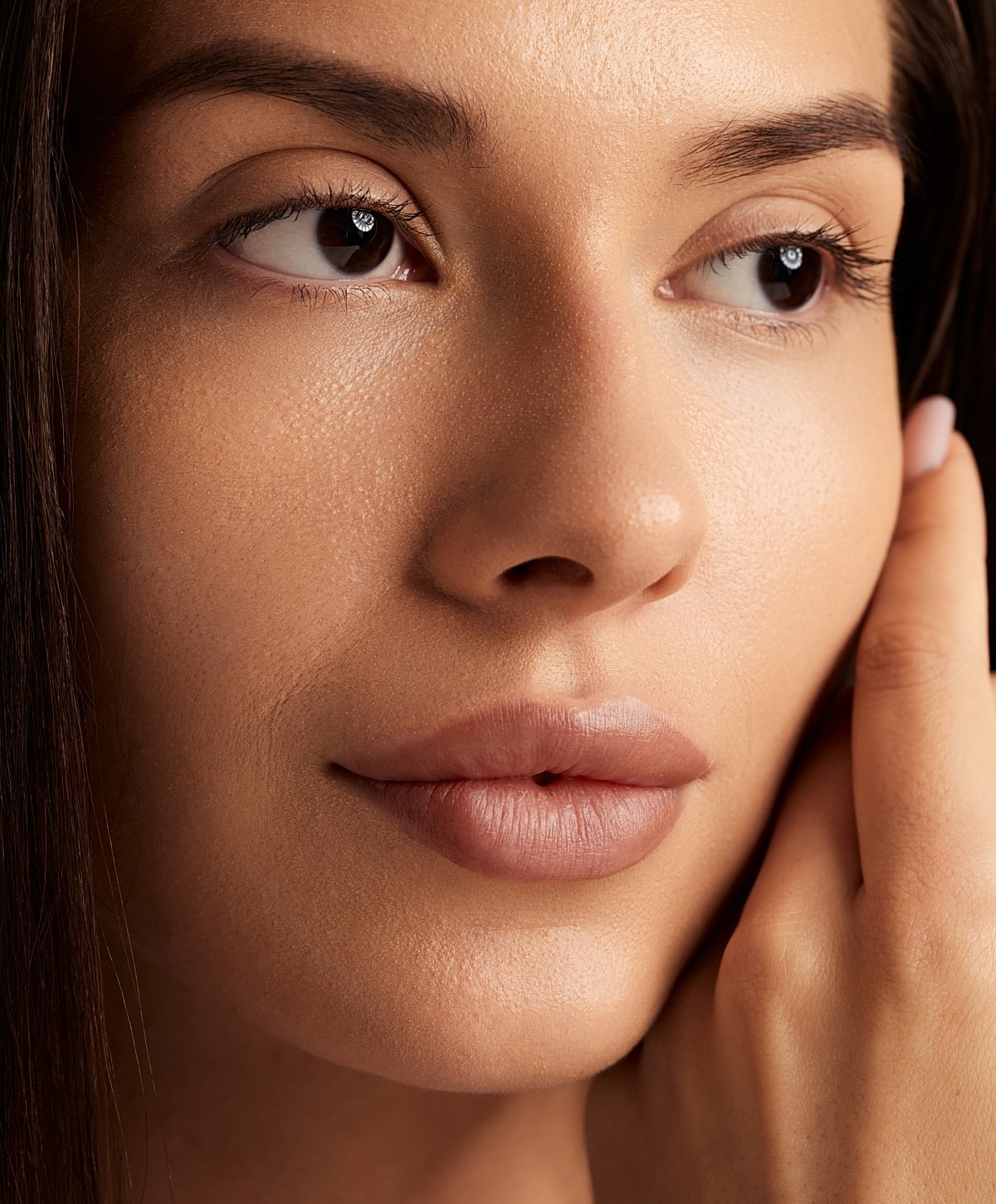 Close-up of a woman's face and hand.