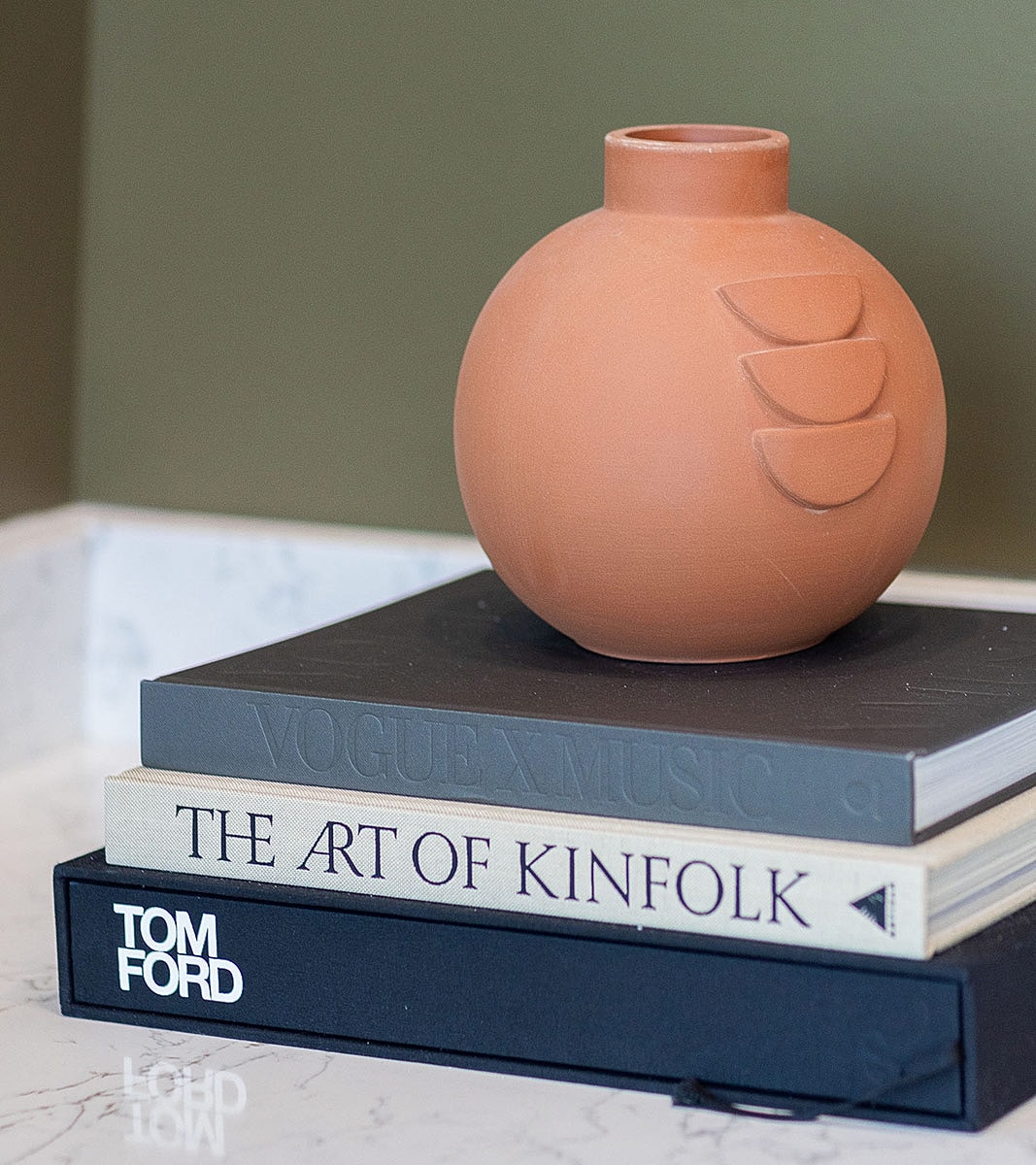 Clay vase on stacked decorative books.