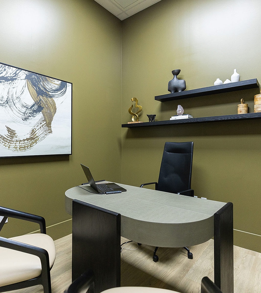 Modern office with green walls and minimalist decor.