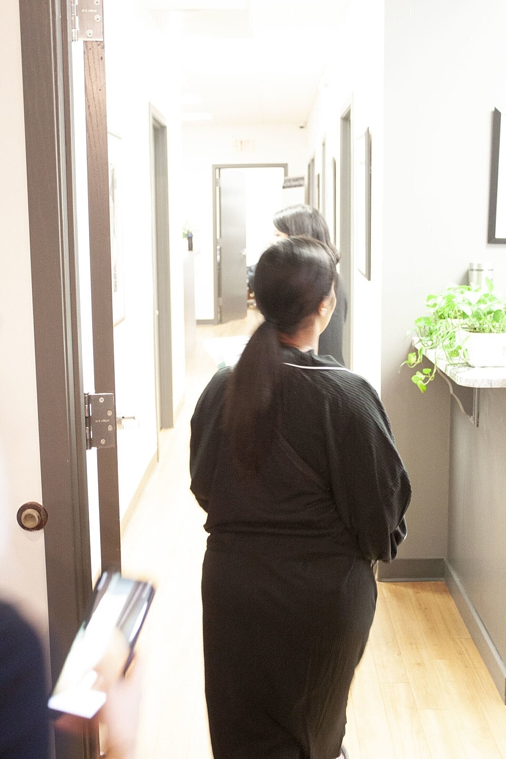 People walking in a modern office hallway.