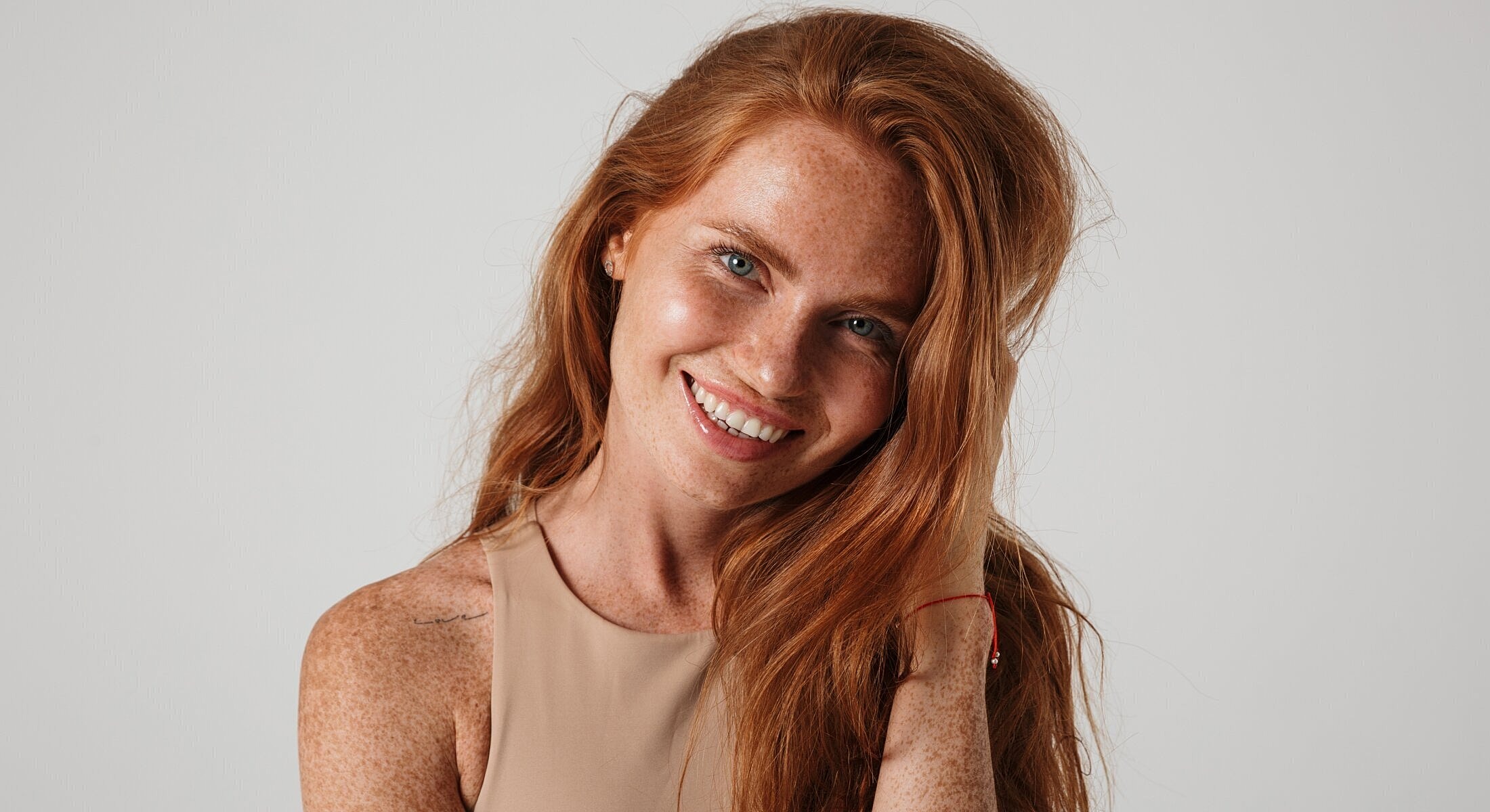 Smiling woman with red hair and freckles.