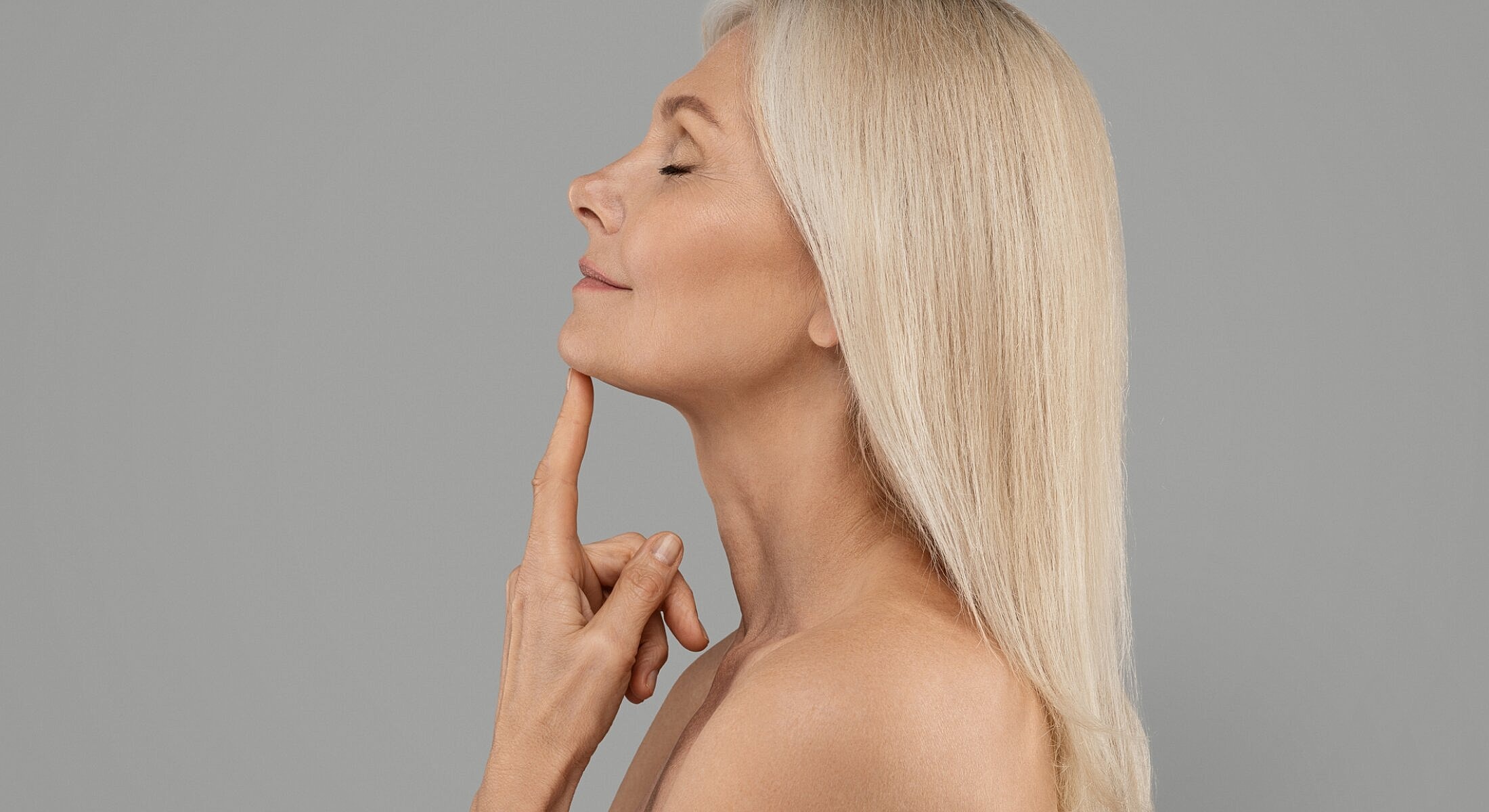 Woman touching her chin, looking contemplative.