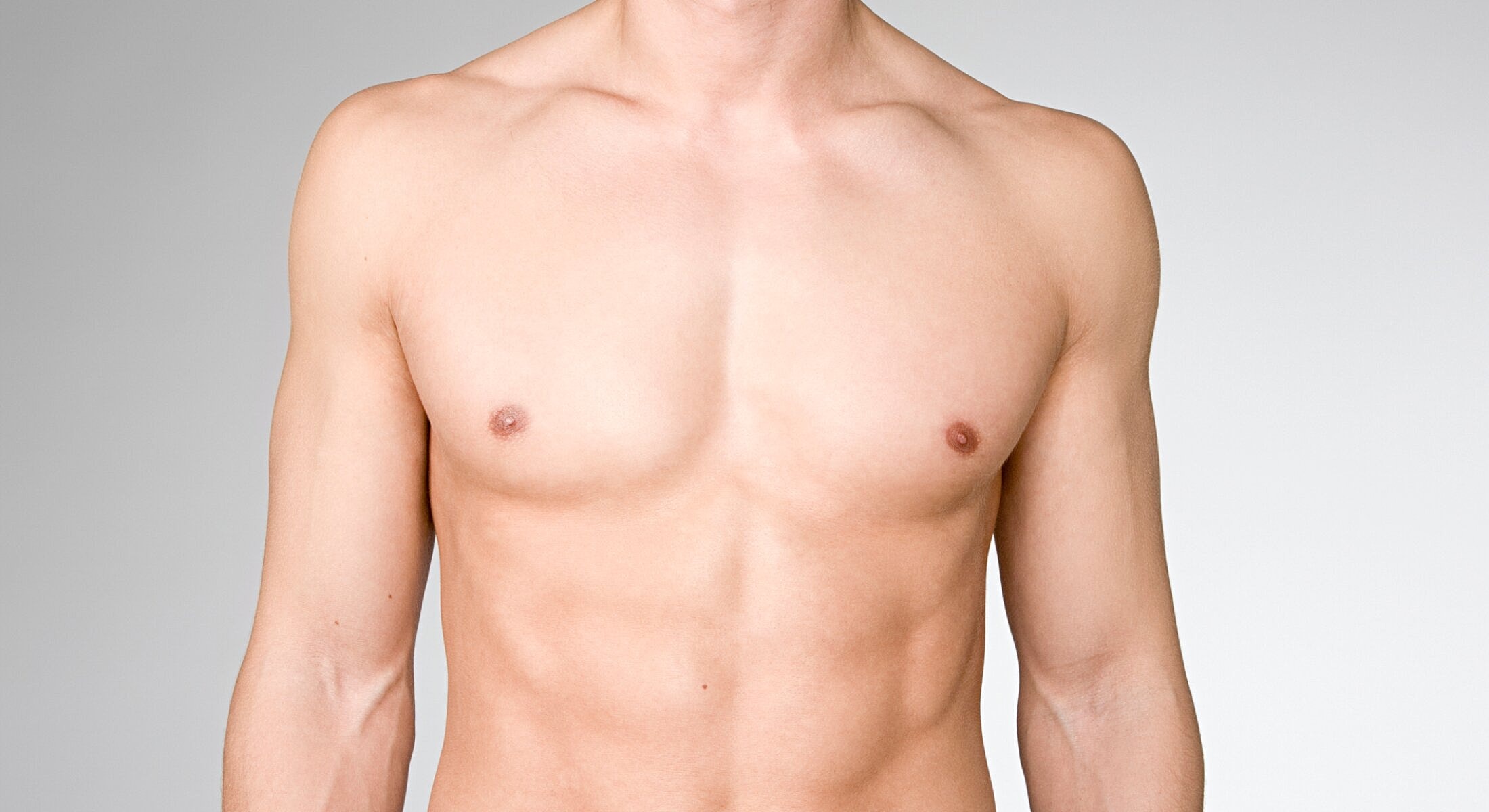 Bare torso of a male model against gray background