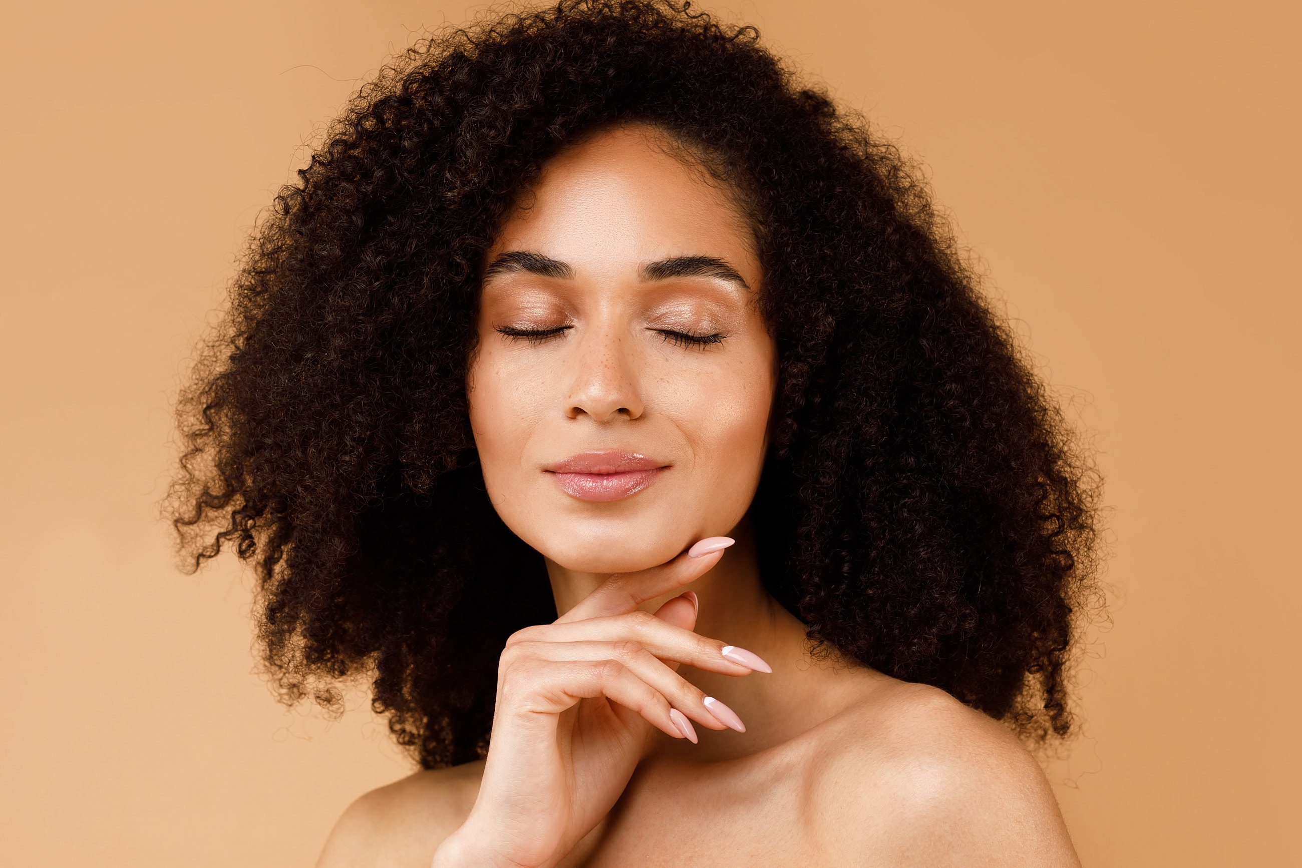 Woman with curly hair posing confidently.